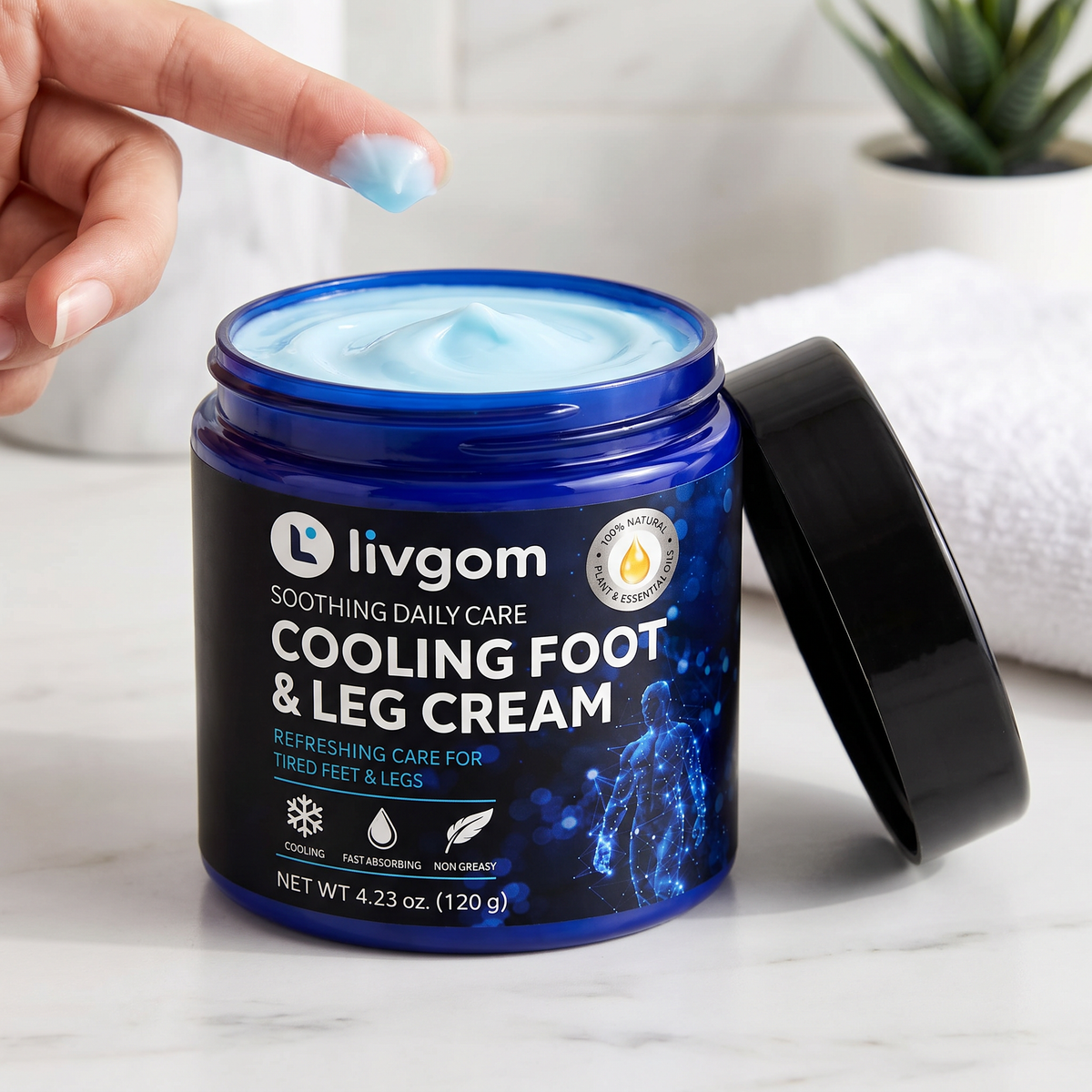Open jar of Livgom Cooling Foot & Leg Cream with light blue cooling cream on a fingertip