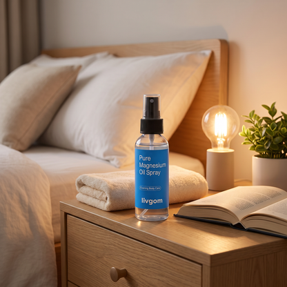 Livgom Magnesium Oil Spray on a bedside table next to a lamp and a book